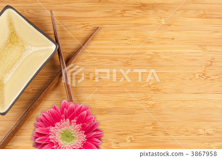 Gerber Daisy, Chopsticks and Dish on a Bamboo Background 3867958