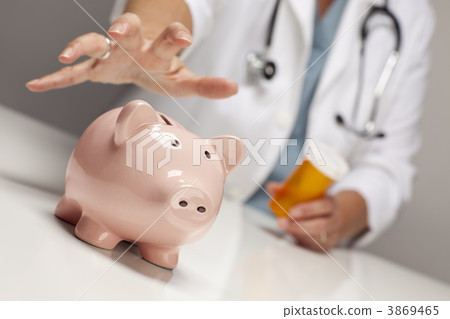 Doctor with Medicine Bottles Reaches for Piggy Bank. 3869465
