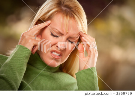 Grimacing Woman Suffering a Headache Grimacing Woman Suffering a Headache 3869759