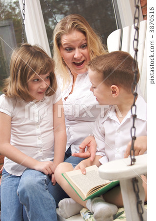 Young Boy Reads to His Mother and Sister 3870516