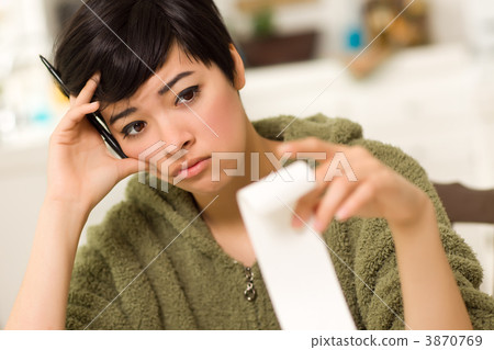 Multi-ethnic Young Woman Agonizing Over Financial Calculations 3870769