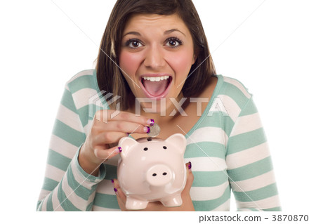 Ethnic Female Putting Coin Into Piggy Bank on White Ethnic Female Putting Coin Into Piggy Bank on White 3870870