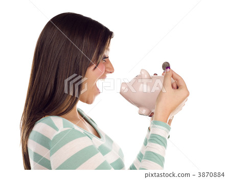Ethnic Female Putting Coin Into Piggy Bank on White Ethnic Female Putting Coin Into Piggy Bank on White 3870884
