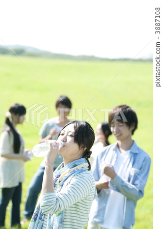 Young people drinking water in the meadow Young people drinking water in the meadow 3887108