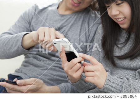 A daughter and a father operating a smartphone A daughter and a father operating a smartphone 3895864