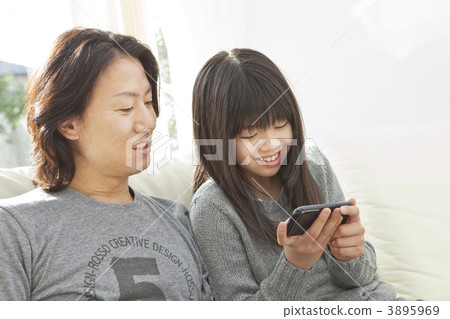 A daughter and a father operating a smartphone A daughter and a father operating a smartphone 3895969