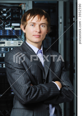 Young businessman in hi-tech datacenter in front of equipment Young businessman in hi-tech datacenter in front of equipment 3932590