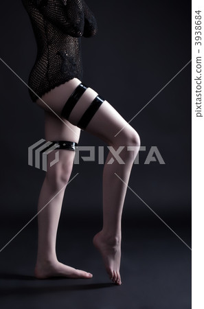 Woman legs in dark with leather strap Woman legs in dark with leather strap 3938684