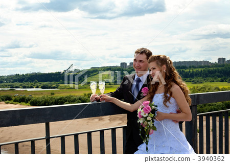 Wedding couple in sunny summer day stand on bridge 3940362