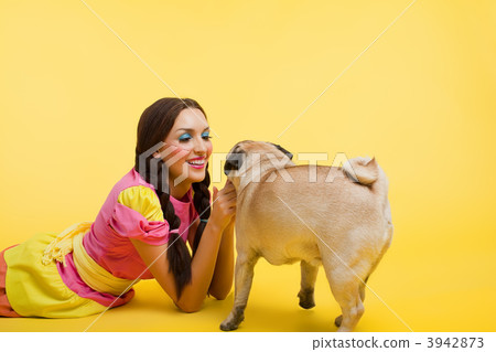 Happy wwoung woman in doll dress feed a small dog 3942873