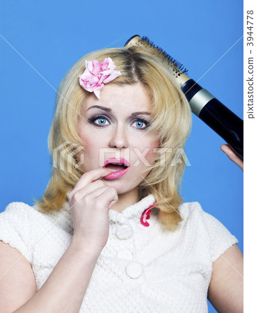 Young blond woman with broken hairdryer 3944778