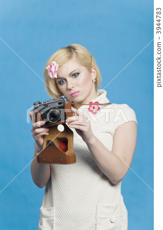 Blond girl look at retro camera 3944783