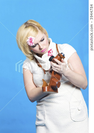 Blond girl look at retro camera Blond girl look at retro camera 3944784