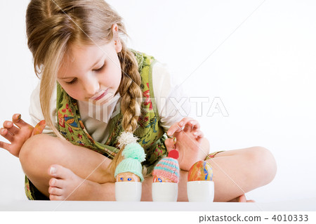 Young girl checking her painted eggs Young girl checking her painted eggs 4010333