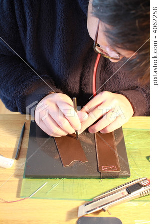 A man punching holes in leather craft A man punching holes in leather craft 4062258
