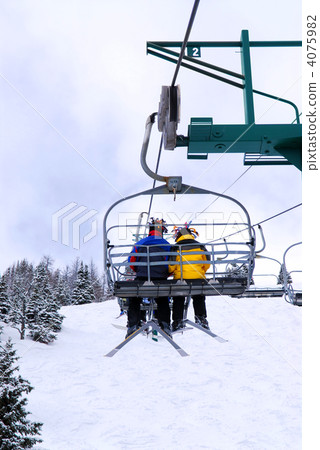 Skiers on chairlift 4075982