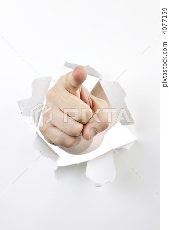 Finger pointing through hole in paper 4077159