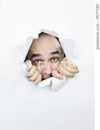 Scared face looking through hole in paper 4077166