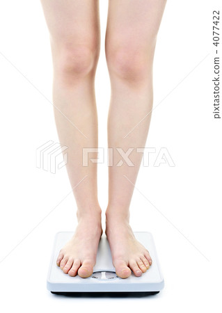 Woman standing on bathroom scale 4077422