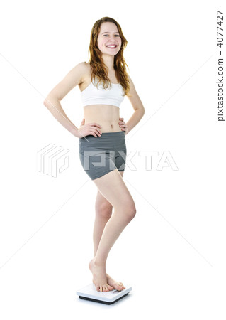 Happy young girl standing on bathroom scale Happy young girl standing on bathroom scale 4077427