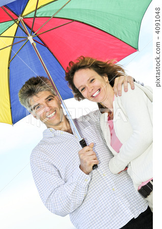 Happy mature couple with umbrella 4091048