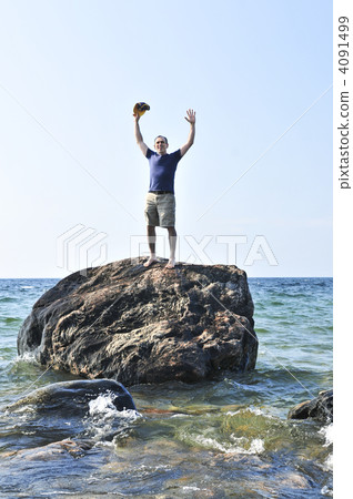 Man stranded on a rock in ocean 4091499
