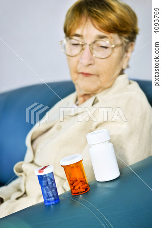 Elderly woman looking at pill bottles Elderly woman looking at pill bottles 4093769