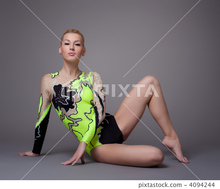 Young woman in gymnast suit posing on grey Young woman in gymnast suit posing on grey 4094244