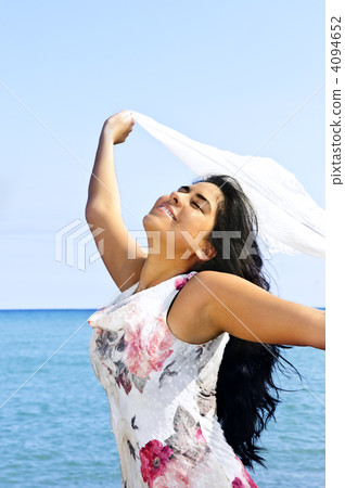 Beautiful young woman at beach with white scarf 4094652