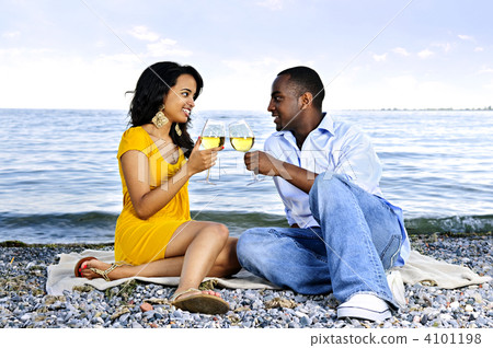 Happy couple having wine on beach 4101198