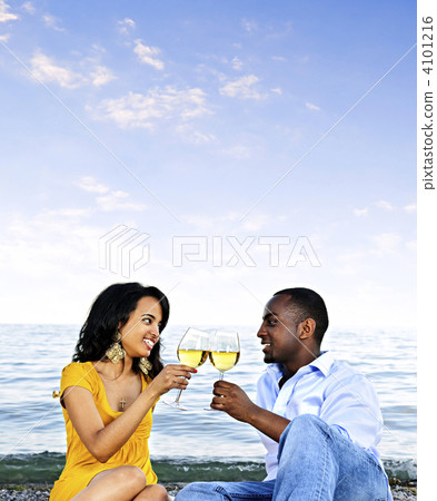 Happy couple having wine on beach 4101216