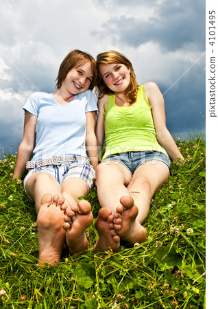 Young girls sitting in meadow Young girls sitting in meadow 4101495