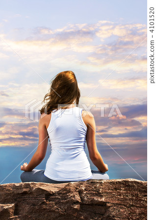 Young girl meditating at sunset 4101520