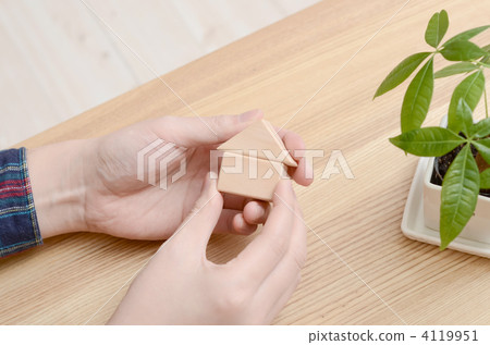 手裡拿著一個木製迷你小屋 手裡拿著一個木製迷你小屋 4119951