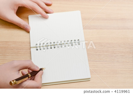 A hand writing in a notebook with a pen A hand writing in a notebook with a pen 4119961