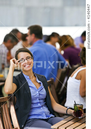 Pretty young woman sitting in garden of a restaurant 4140447