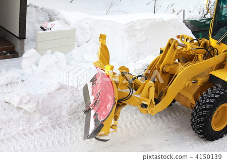 A wheel loader clearing snow from a residential area A wheel loader clearing snow from a residential area 4150139