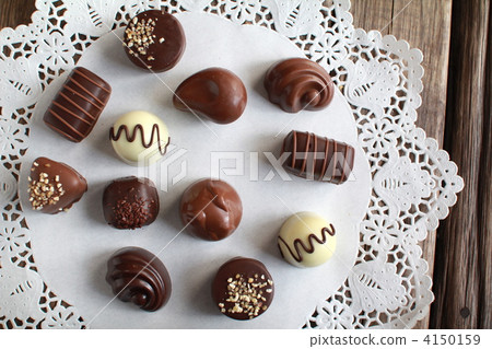 Various kinds of chocolate bonbons placed on lace paper 4150159