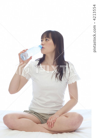 A woman drinking water in bed A woman drinking water in bed 4213554