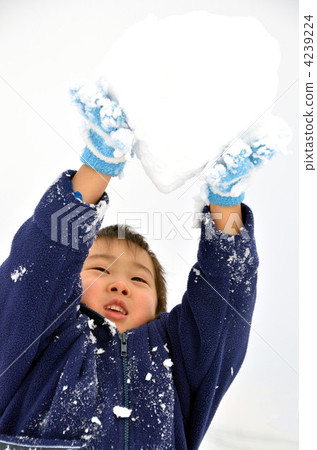 A boy lifting a snowball A boy lifting a snowball 4239224