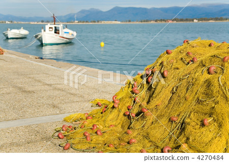 End of fishing day. White boats and yellow fishing net with clea 4270484