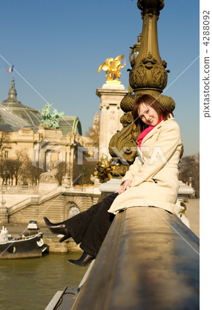 Happy beautiful woman sitting on the balustrade of the Pont Alex 4288092