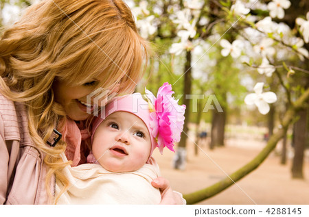 Beautiful young mother and baby daughter having fun outdoors at Beautiful young mother and baby daughter having fun outdoors at 4288145