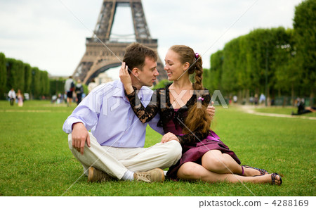 Happy romantic couple in Paris, sitting on grass by the Eiffel T 4288169