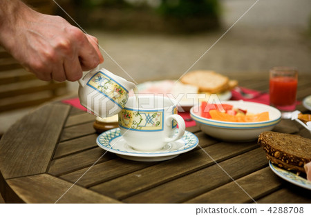 Tasty breakfast served outdoors. Man is pouring milk in coffee Tasty breakfast served outdoors. Man is pouring milk in coffee 4288708