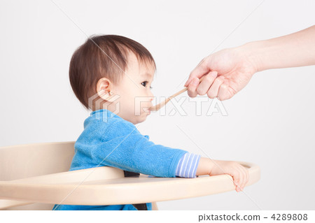 Baby eating baby food with a spoon of wood 2 4289808