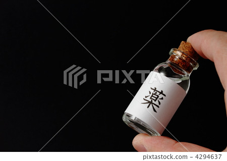Hand holding a vial of "medicine" label 4294637