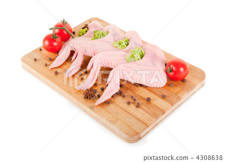 Raw chicken wings with condiments on chopping board Raw chicken wings with condiments on chopping board 4308638