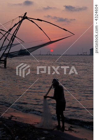 Fisherman and chinese fishnets on sunset. Kochi, Kerala, India 4324604