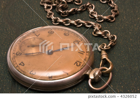 Old clock with chain lying on rough green surface Old clock with chain lying on rough green surface 4326052
